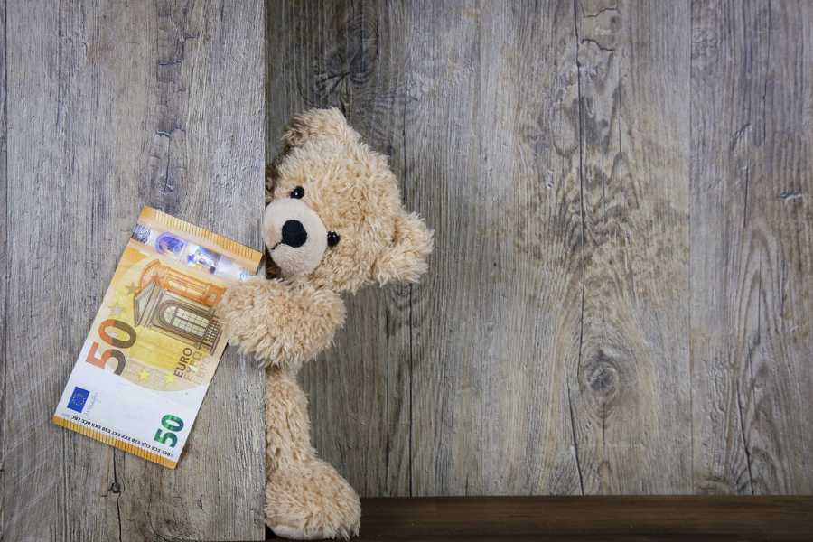 Muñeco infantil con dinero que refiriéndose a la Pensión de alimentos